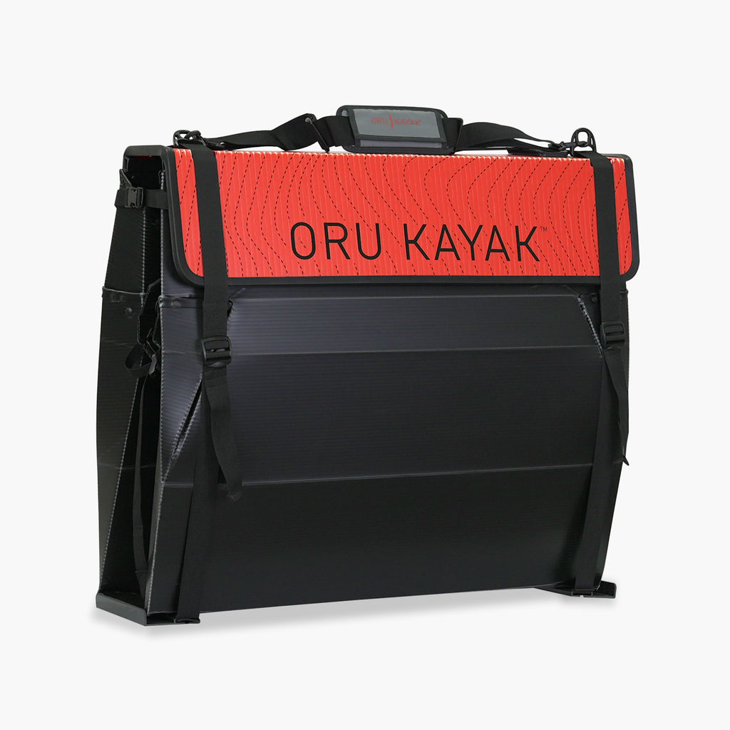 Folded white Oru Kayak Beach model in black in box form.