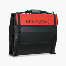 Folded white Oru Kayak Beach model in black in box form.