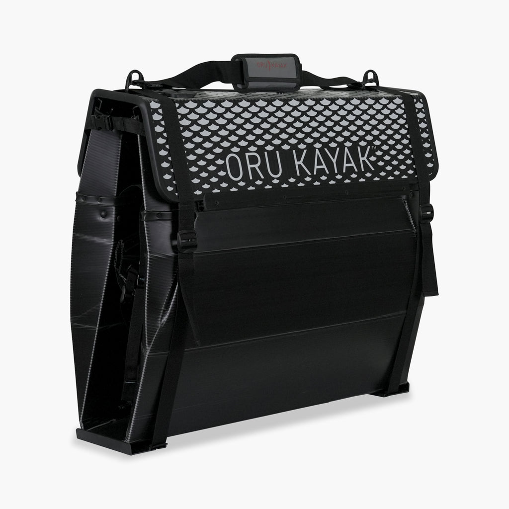 Folded white Oru Kayak Beach Sport model in black in box form.