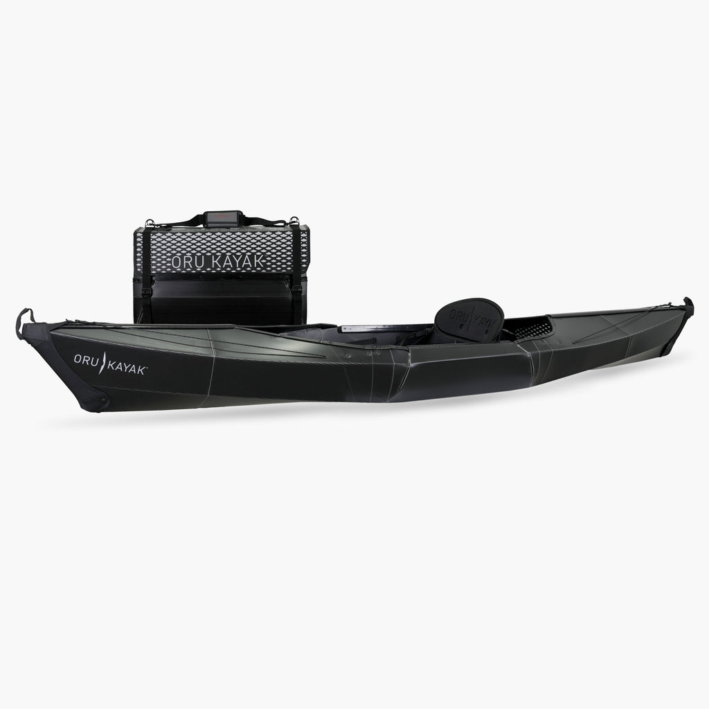 Side view of the Oru Kayak Beach Sport model in black, shown fully assembled in front of its compact folded box form.