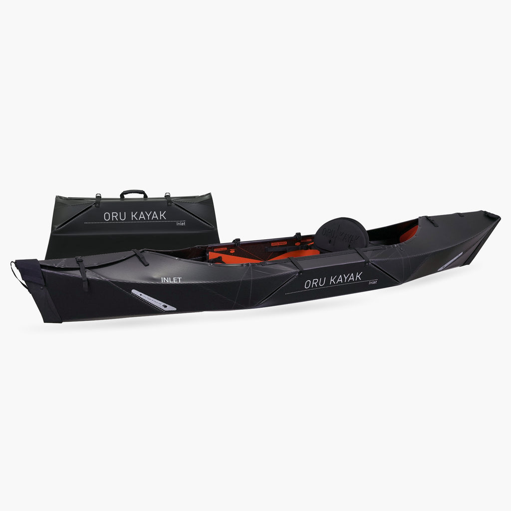 Side view of the Oru Kayak Inlet model in black, shown fully assembled in front of its compact folded box form.